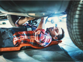 Autoreparatur Ein Mann arbeitet unter einem Auto