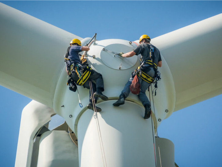 Arbeiten am Windrad Zwei Männer arbeiten in der Höhe an einem Windkraftrad